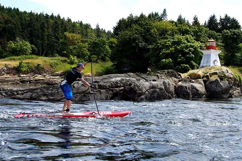 Simon Whitfield paddling by the lighthouse on the way from Vancouver to Victoria