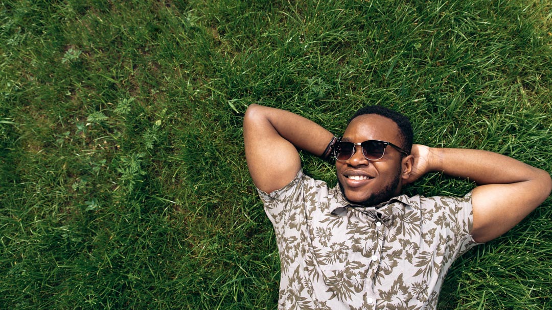 man lying on grass smiling