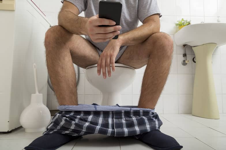 Guy sitting on the toilet seat