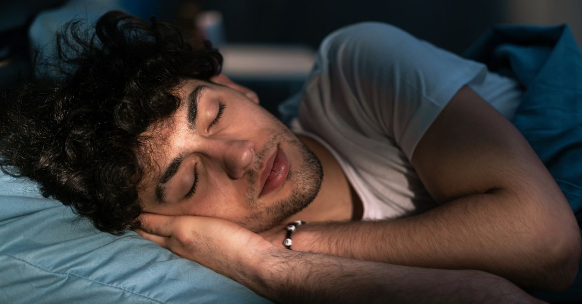 man sleeping in bed with light on his face