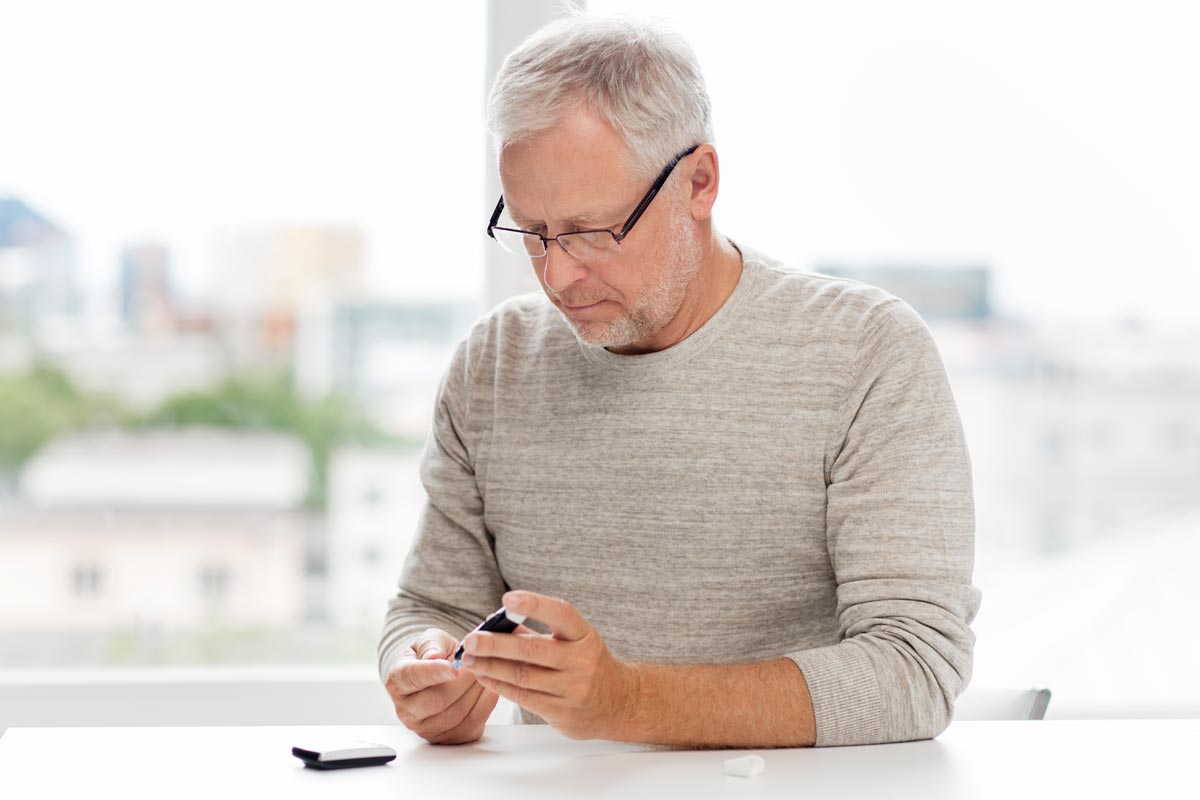 man using device to test blood sugar diabetes