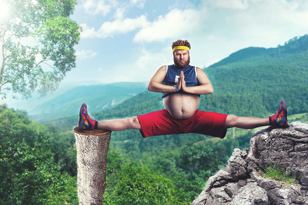 Overweight man balancing on a cliff