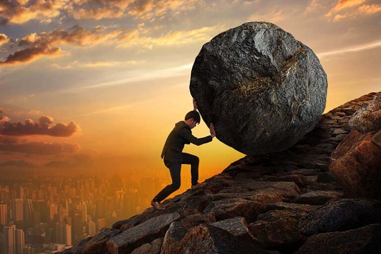 Man pushing a massive boulder uphill