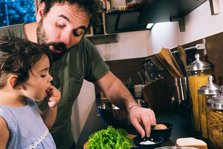 Father and daughter preparing a meal together