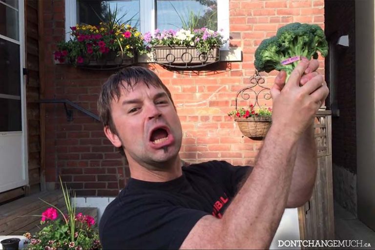 Adam Bisby takes the Men's Health Week plegde while holding up broccoli