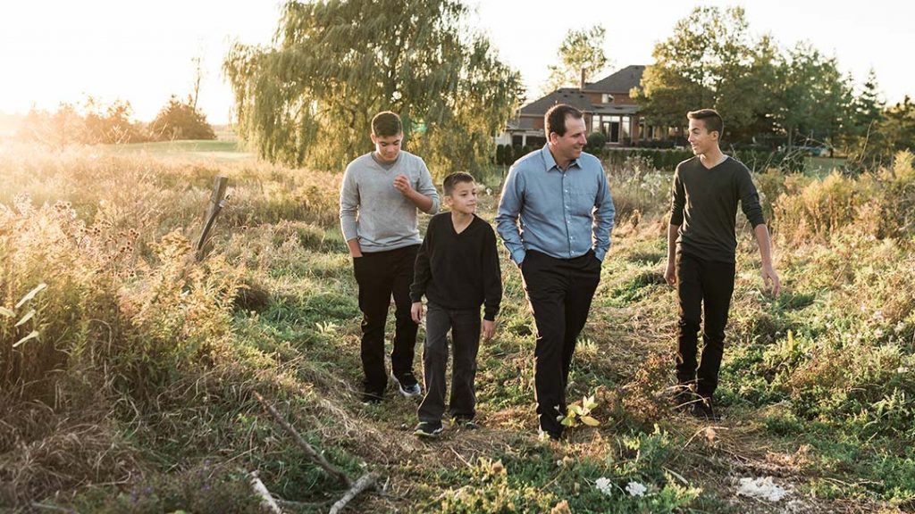 Retired CFLer Joe Sardo walks outdoors with his sons