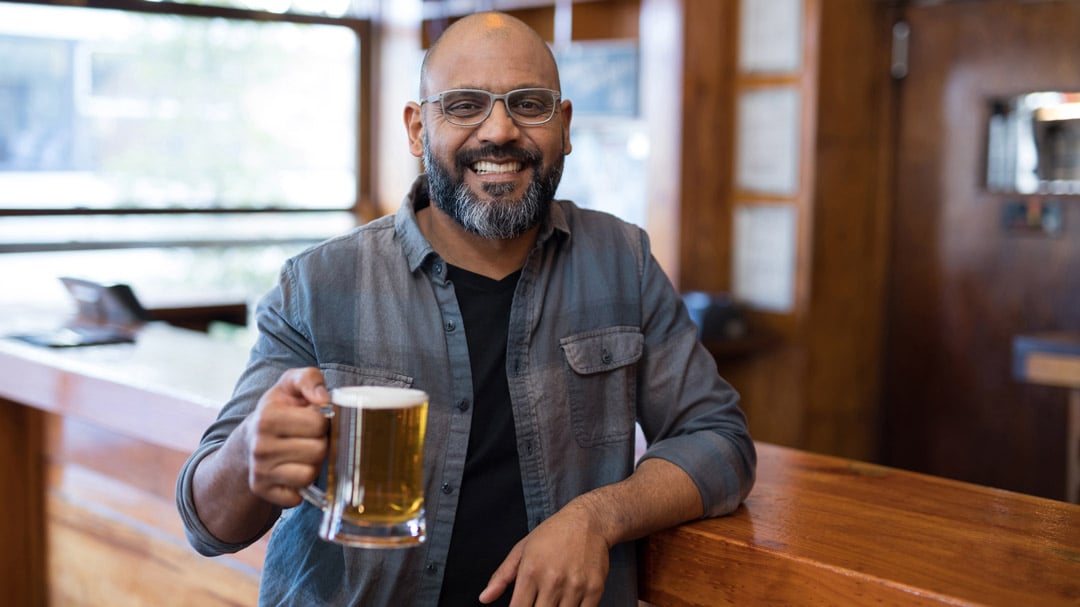 South Asian man drinking beer