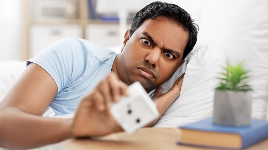 Man pressing snooze button