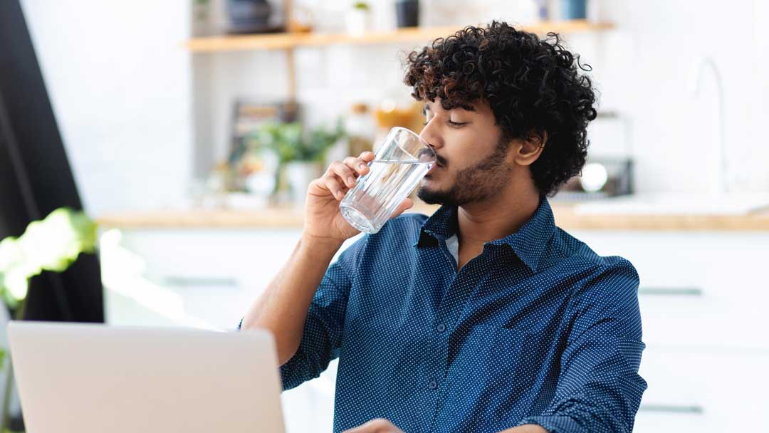 South Asian man drinking water