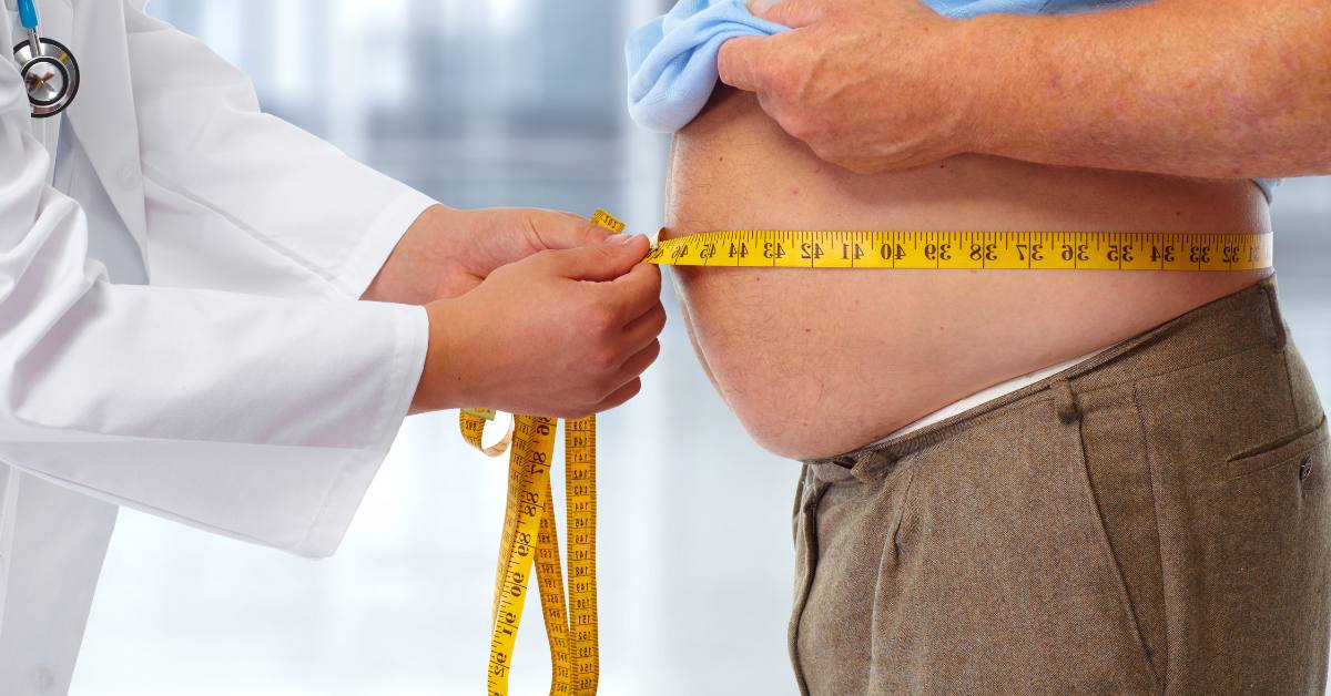 doctor measuring man's belly