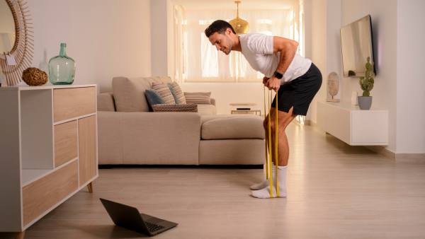 man working out at home using resistance band