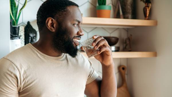 man drinking a glass of water