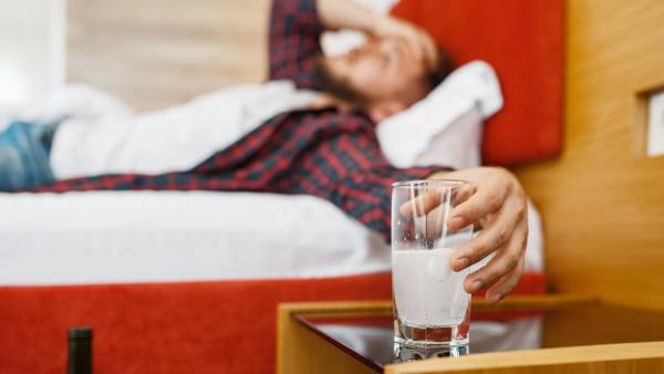 man with hangover in bed