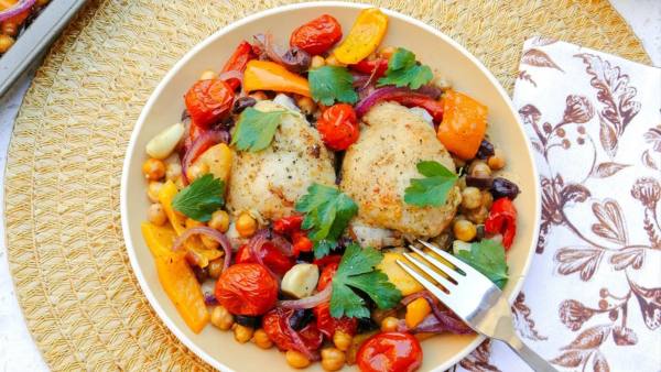 plate of roasted chicken with veggies and a fork