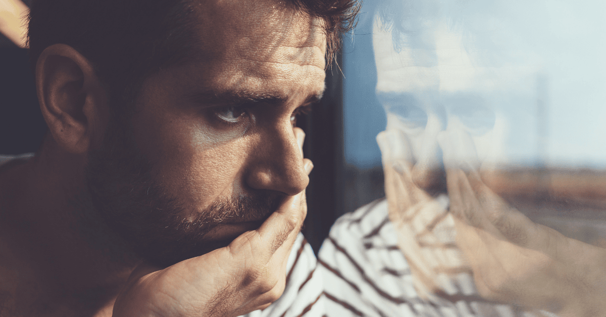 man looking sad out of window