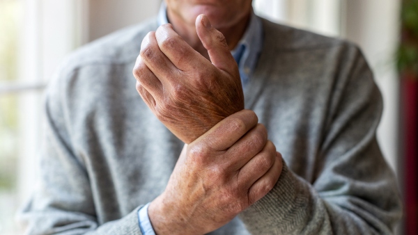 old man grabbing wrist