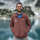 Rehmatullah Sheikh standing in front of mountains and water