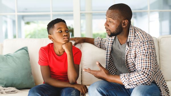 father and son talking on couch
